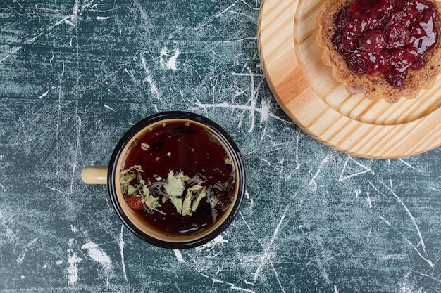 Free photo tart cake on wooden plate with cup of tea. high quality photo