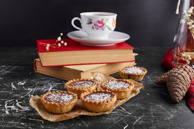 Tartalettes with chocolate stuffing and coconut with a cup of tea. 