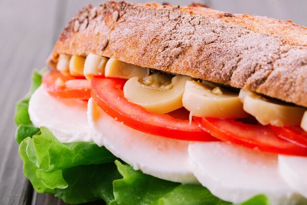 Tasteful sandwich made of sliced mushrooms, tomatoes, boiled eggs and salad