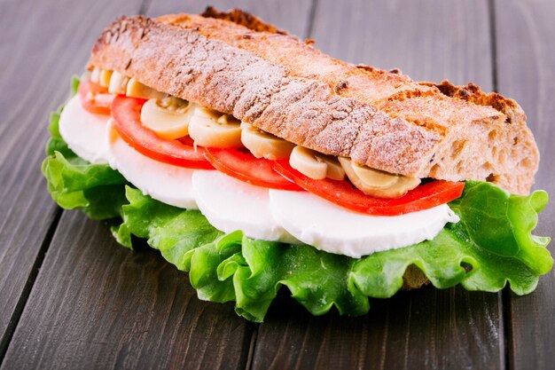 Tasteful sandwich made of sliced mushrooms, tomatoes, boiled eggs and salad