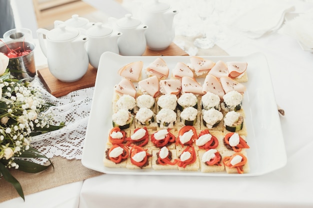 Tasty appetizers of fish and vegetables served on square plate