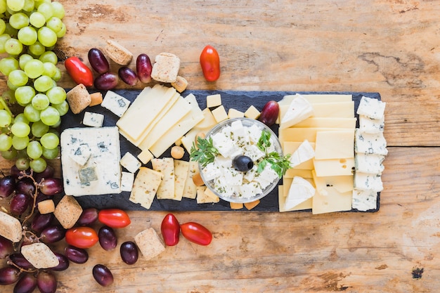 Tasty appetizers with cheese plate, tomatoes and grapes