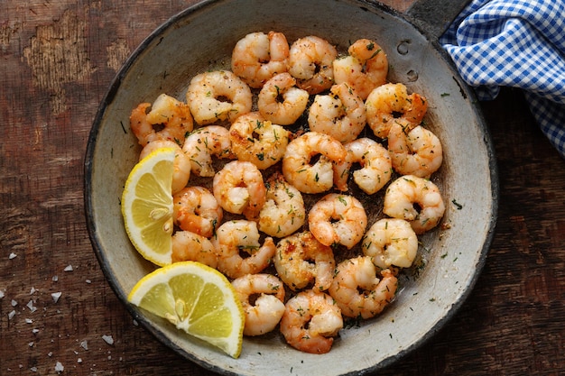 Tasty appetizing fried shrimps on pan on dark stone background. Top View.