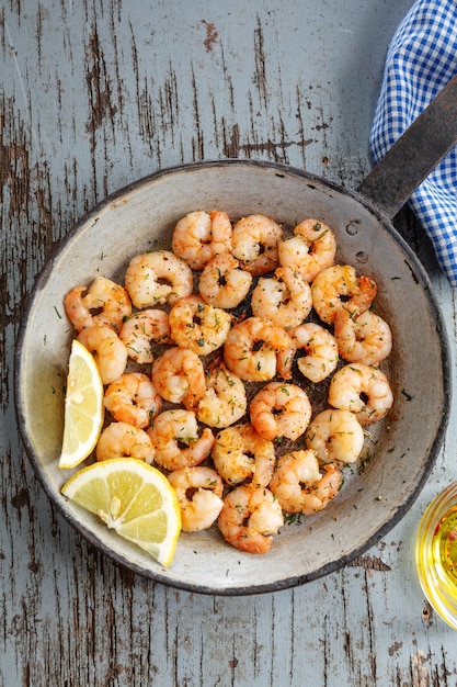 Free photo tasty appetizing fried shrimps on pan on dark stone background. top view.