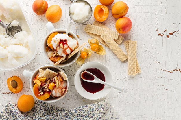 Tasty appetizing ingredients for cooking vanilla ice cream with ice cream spooons and fruits. Top View with Copy Space.