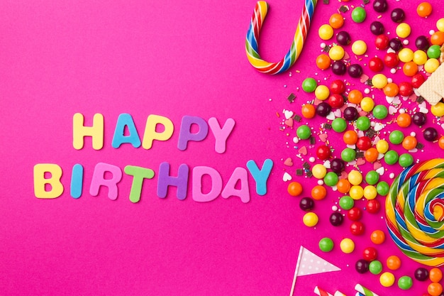 Free photo tasty appetizing party accessories happy birthday on bright pink background
