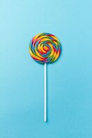 tasty appetizing party accessory sweet swirl candy lollypop on blue background top view