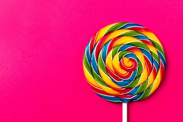 Бесплатное фото Вкусный аппетитный аксессуар для вечеринки sweet swirl candy lollypop на розовом фоне