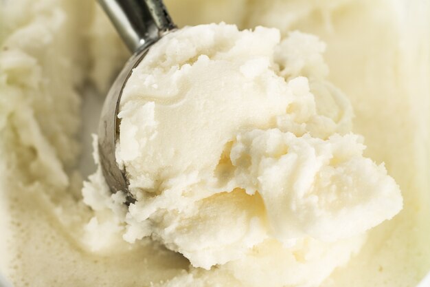 Tasty appetizing pure vanilla creamy ice cream with in ice cream spoon. Closeup. Horizontal with Copy Space.