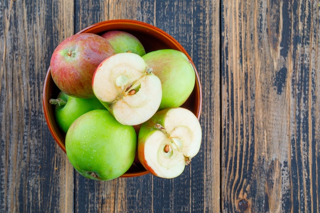 Tasty apples in a bowl on a wooden background. flat lay.
