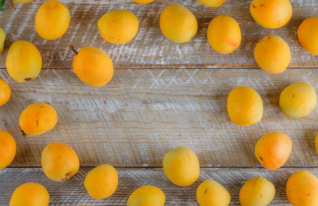 Tasty apricots on wooden table, flat lay.