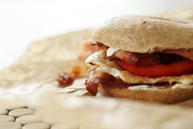 Tasty bagel sandwich with bacon