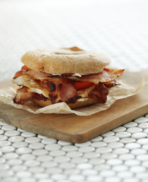 Tasty bagel sandwich with bacon