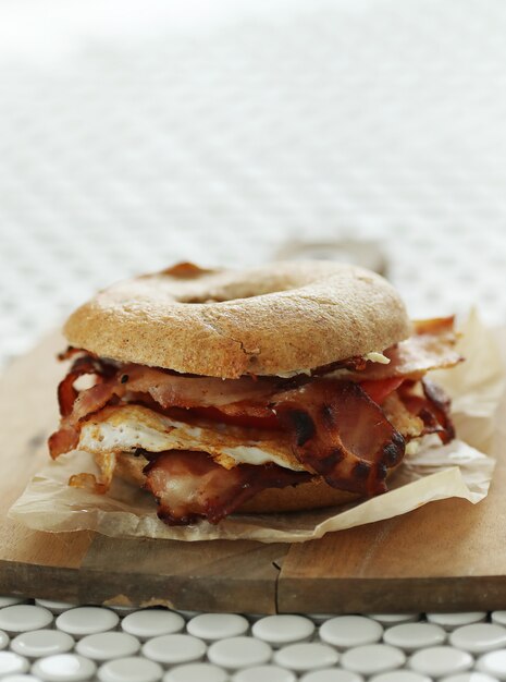 Tasty bagel sandwich with bacon