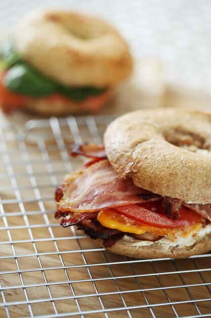 Tasty bagel sandwich with bacon