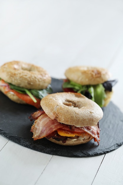 Tasty bagel sandwich with bacon