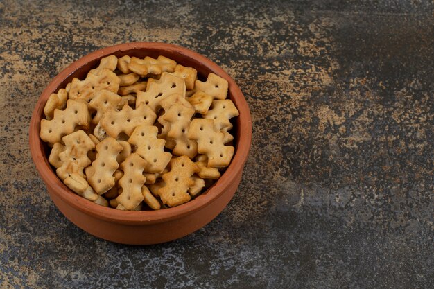 Tasty baked crackers in ceramic bowl.