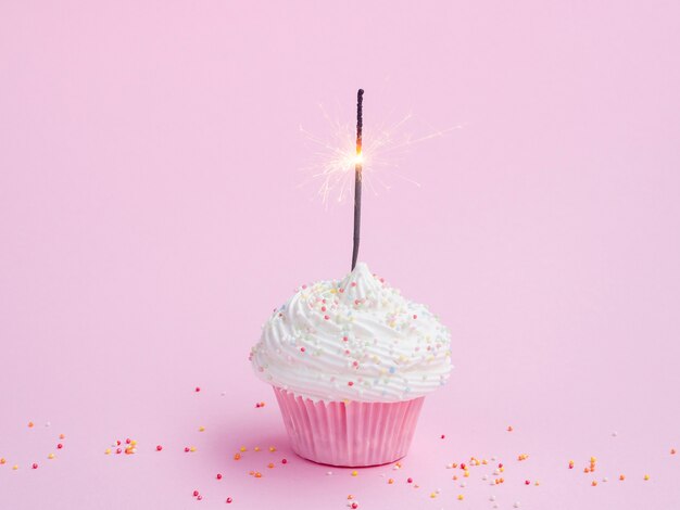 Tasty birthday muffin on pink background