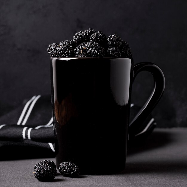 Tasty blackberries in mug front view