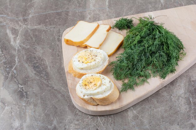 白パンにゆで卵、木の板に野菜を添えたおいしいゆで卵。高品質の写真