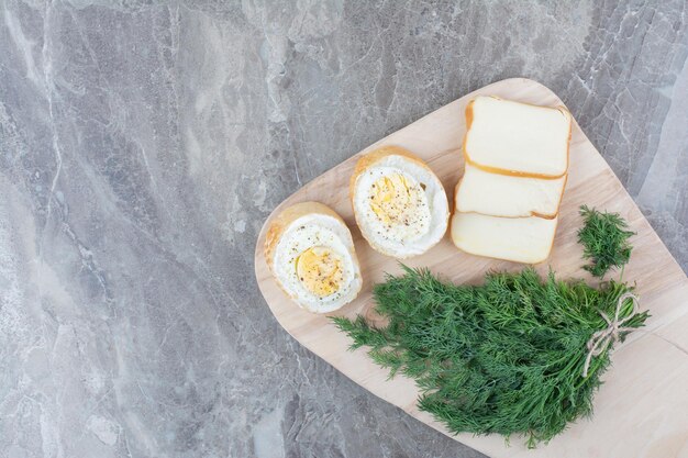 白パンにゆで卵、木の板に野菜を添えたおいしいゆで卵。高品質の写真