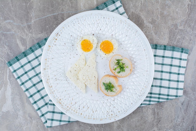 Tasty boiled eggs with spices and bread on tablecloth. High quality photo