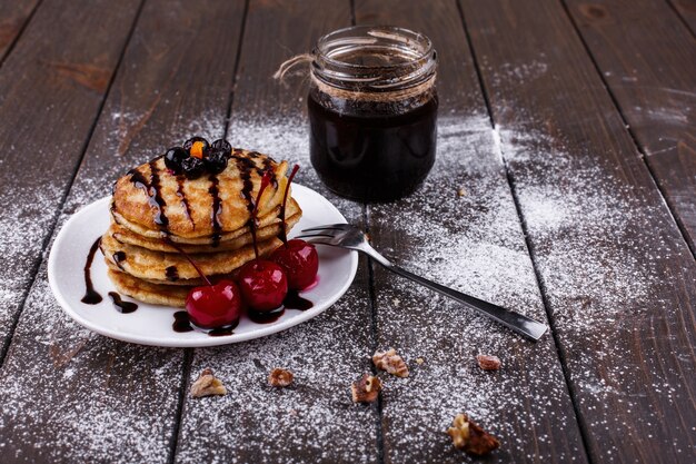 Tasty breakfast. Delicious pancakes covered with chocolate and cherries