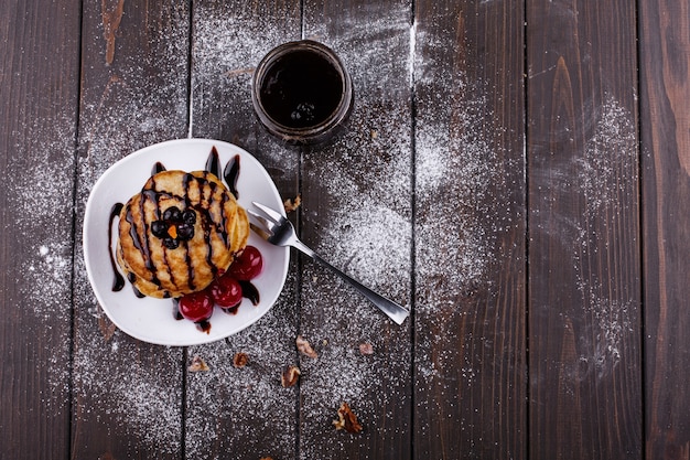 Tasty breakfast. Delicious pancakes covered with chocolate and cherries