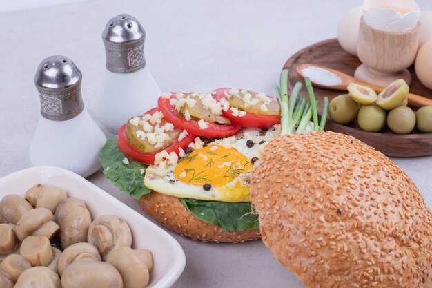 Tasty burger with mushrooms and eggs .