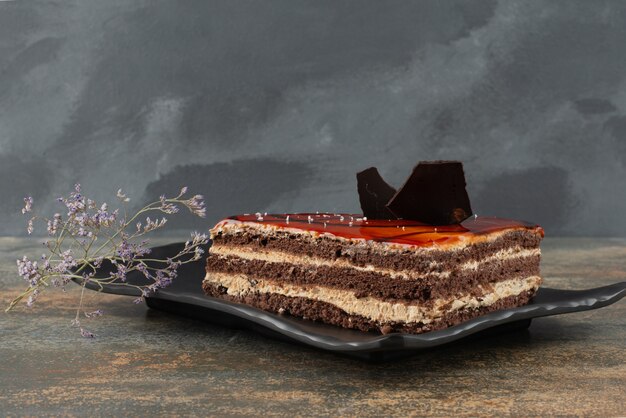 대리석 표면에 꽃과 함께 접시에 맛있는 케이크.