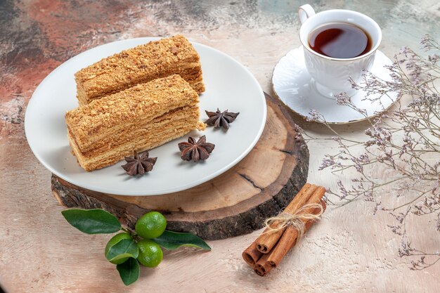 tasty cake slices with cup of tea on grey