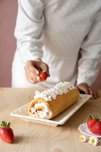 Tasty cake with whipped cream on table