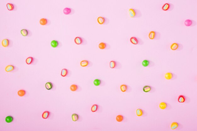 Вкусные конфеты на розовом фоне