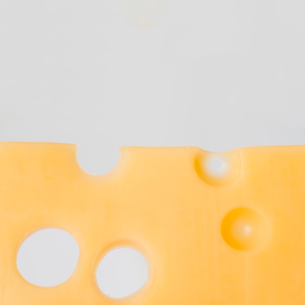 Free photo tasty cheese with holes on white board