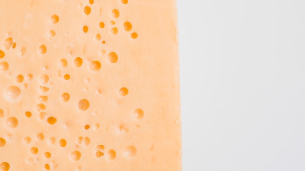 Tasty cheese with many holes on white board