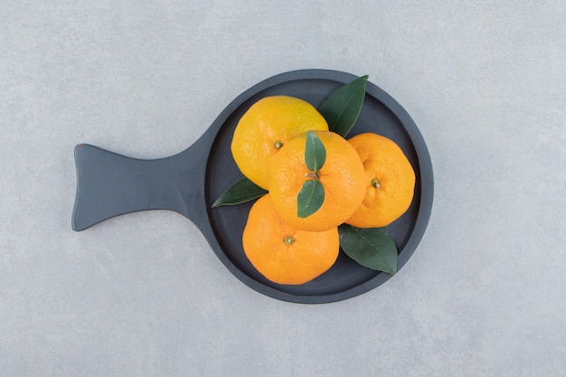 Tasty clementine fruits on black board