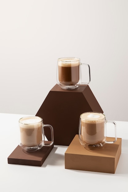 Free photo tasty coffee cups with foam high angle