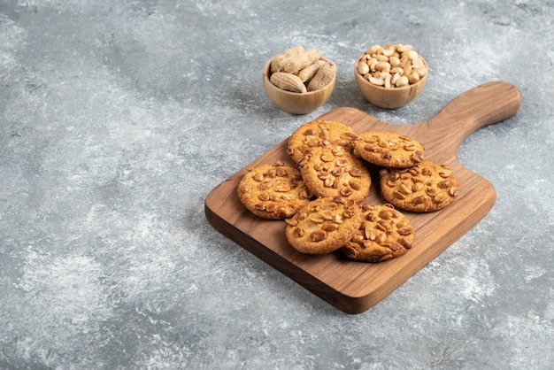 Tasty cookies with organic peanuts and honey on wooden board. 