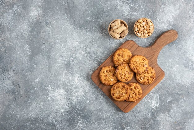 Tasty cookies with organic peanuts and honey on wooden board. 