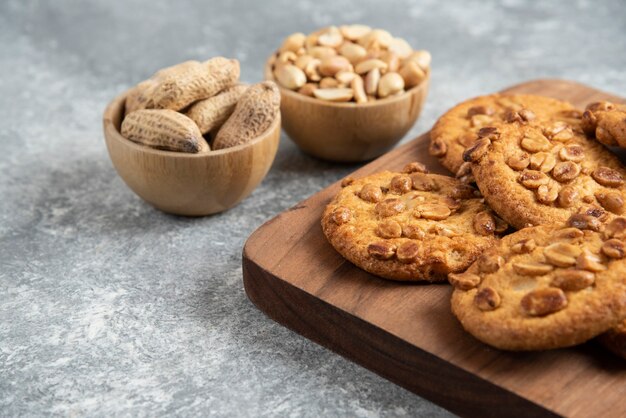 Tasty cookies with organic peanuts and honey on wooden board. 