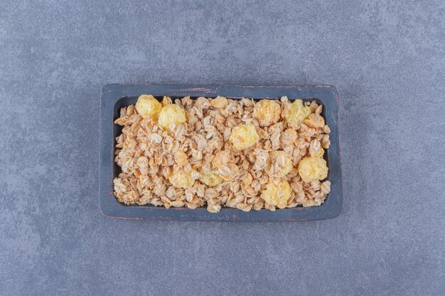 Tasty cornflakes in a board, on the marble table.