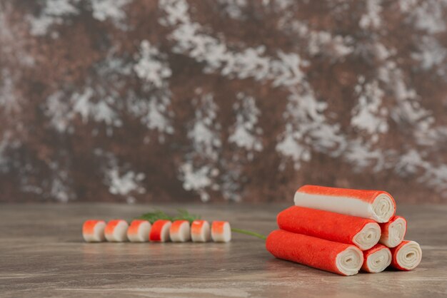 Tasty crab sticks on marble table .