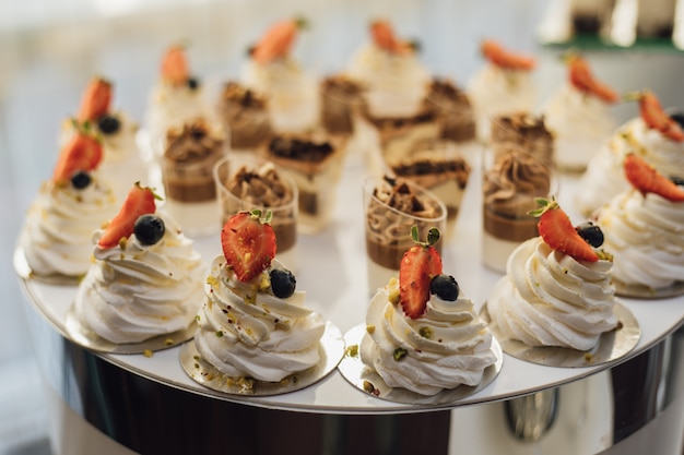 Tasty creamy desserts decorated with strawberry slices and tiramisu