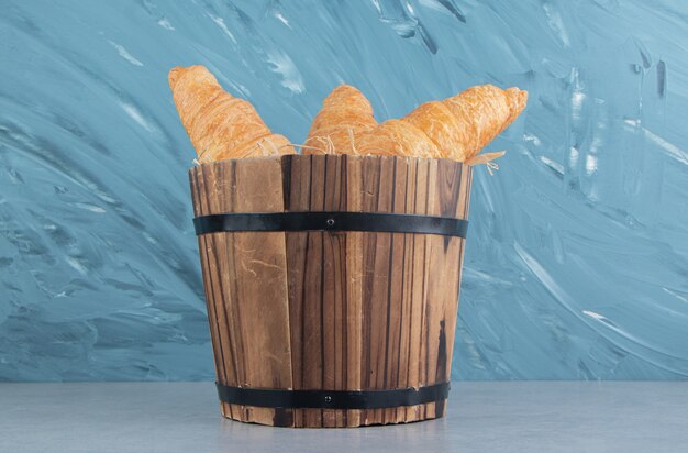 Tasty croissant in the bucket ,on the marble background. High quality photo