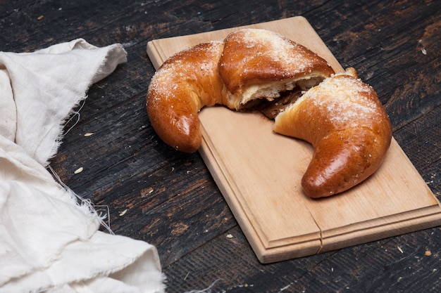 Tasty croissant on wooden surface