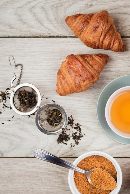 Tasty croissants and tea close-up