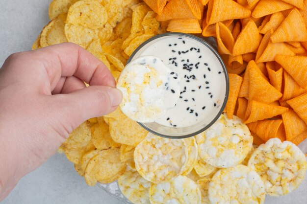 Tasty crucnhy potato chips with sauce on white background. High quality photo