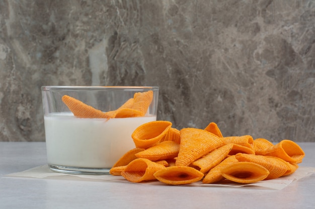 Tasty crucnhy potato chips with sauce on white background. High quality photo