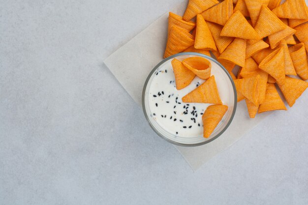 Tasty crucnhy potato chips with sauce on white background. High quality photo