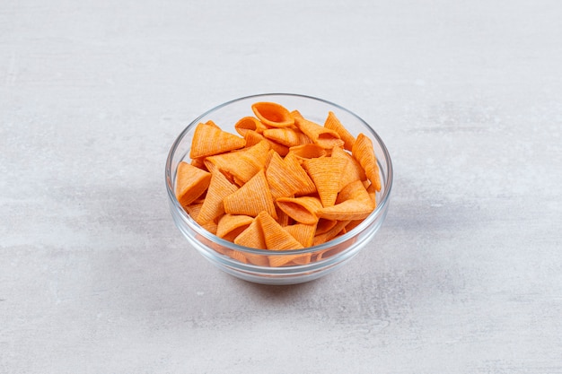 Tasty crunchy chips in glass bowl.